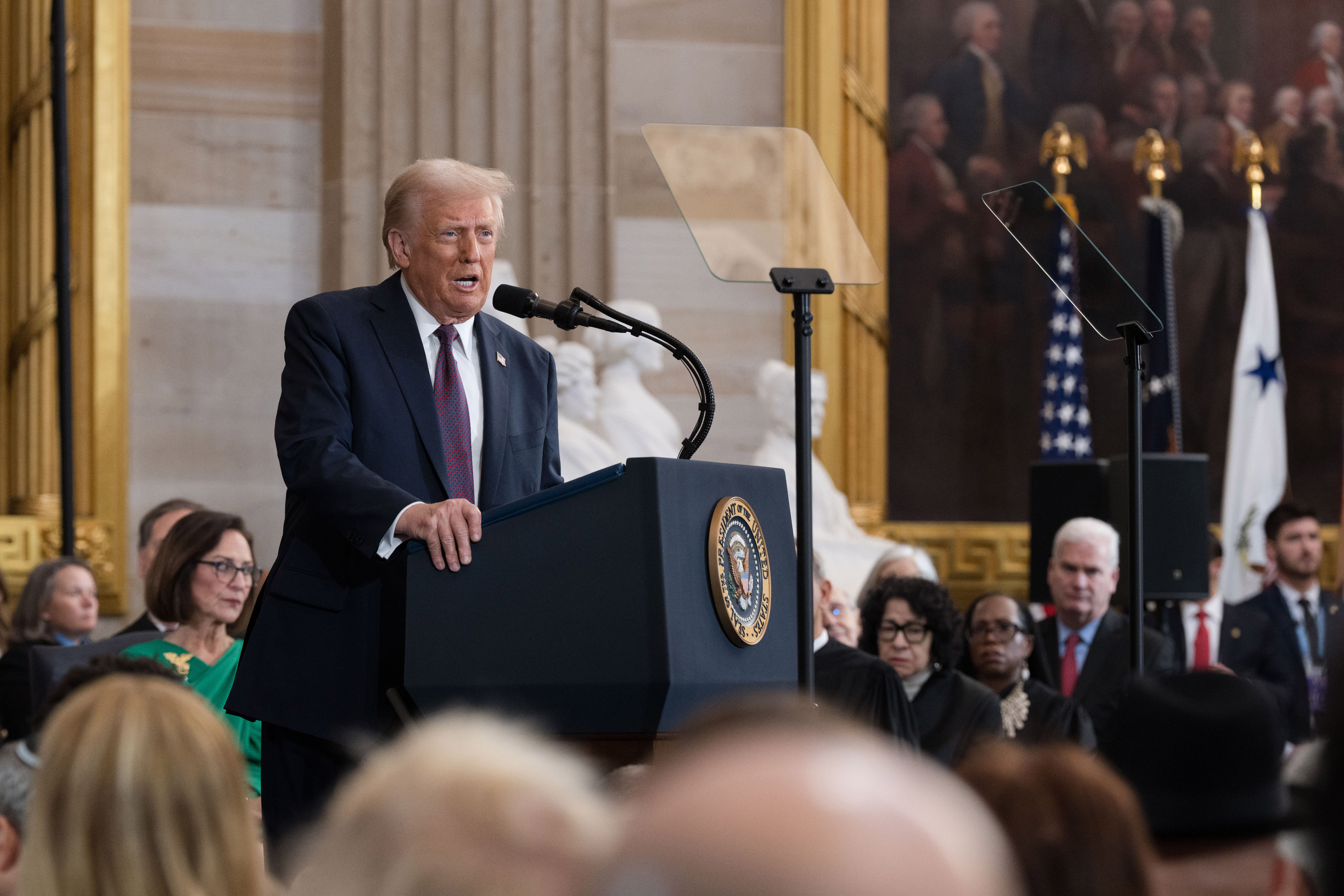 A photo of President Trump speaking at a podium after being sworn in.