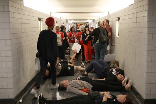 A photo of a die-in staged at a statehouse.