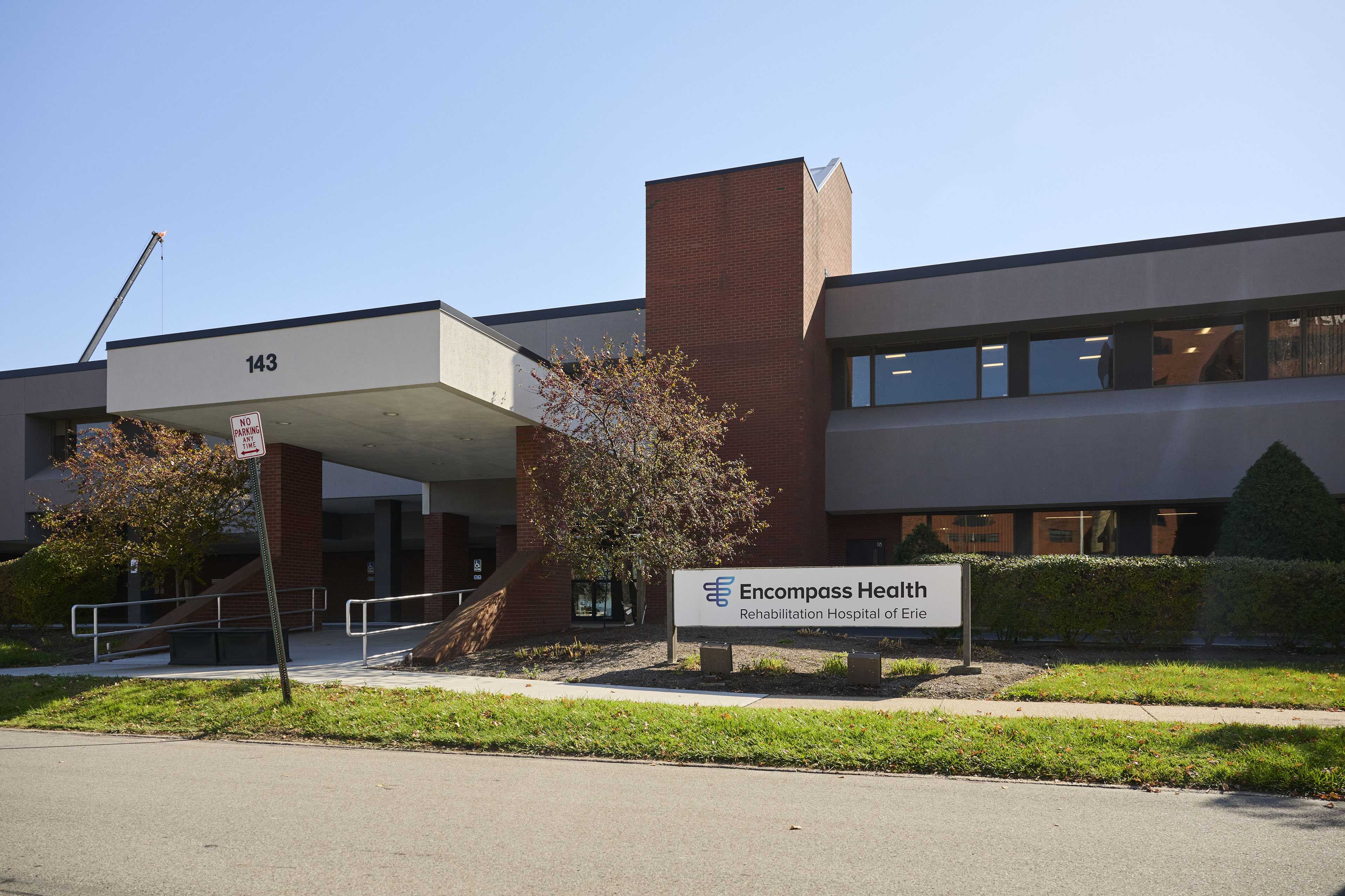 The exterior of a building with a sign for "Encompass Health Rehabilitation Hospital of Erie"