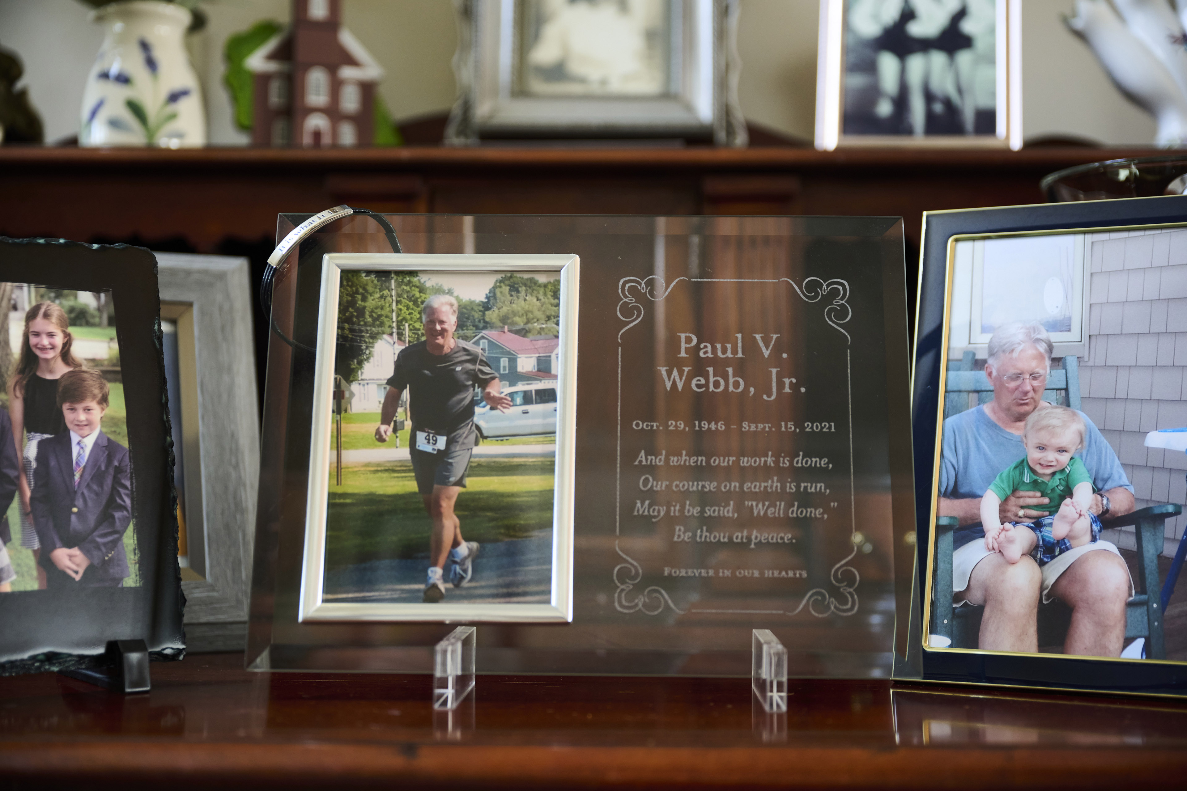 Three framed photos sit on a wooden ledge, with an engraving in the middle for "Paul V. Webb, Jr."