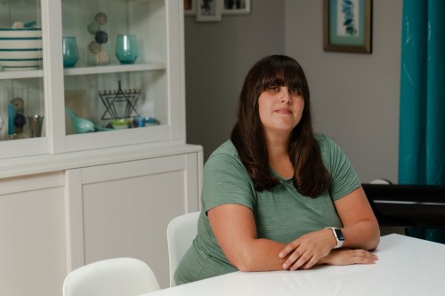 A portrait of a woman sitting at a dining room table.