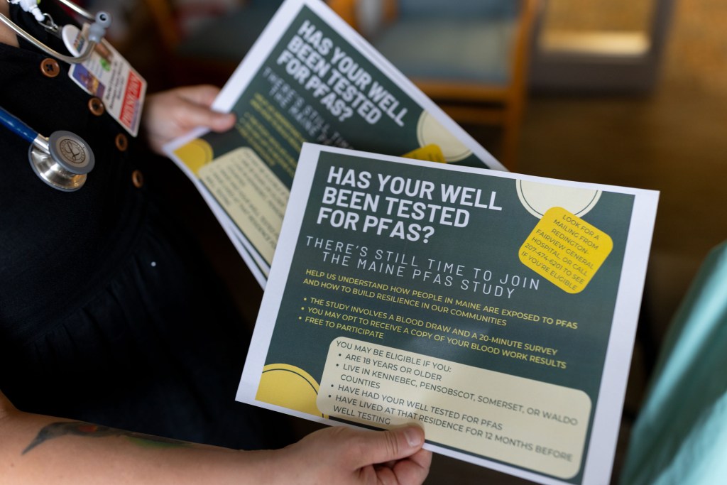 A close up shot of a woman holding informational papers. They read: "Has your well been tested for PFAS? / There's still time to join the Maine PFAS study. / Help us understand how people in Maine are exposed to PFAS and how to build resilience in our communities. / The study involves a blood draw and a 20-minute survey. / You may opt to receive a copy of your blood work results. / Free to participate. / You may be eligible if you: are 18 years or older; live in Kennebec, Pensobscot, Somerset, or Waldo counties; have had your well tested for PFAS; have lived at that residence for 12 months before well testing."