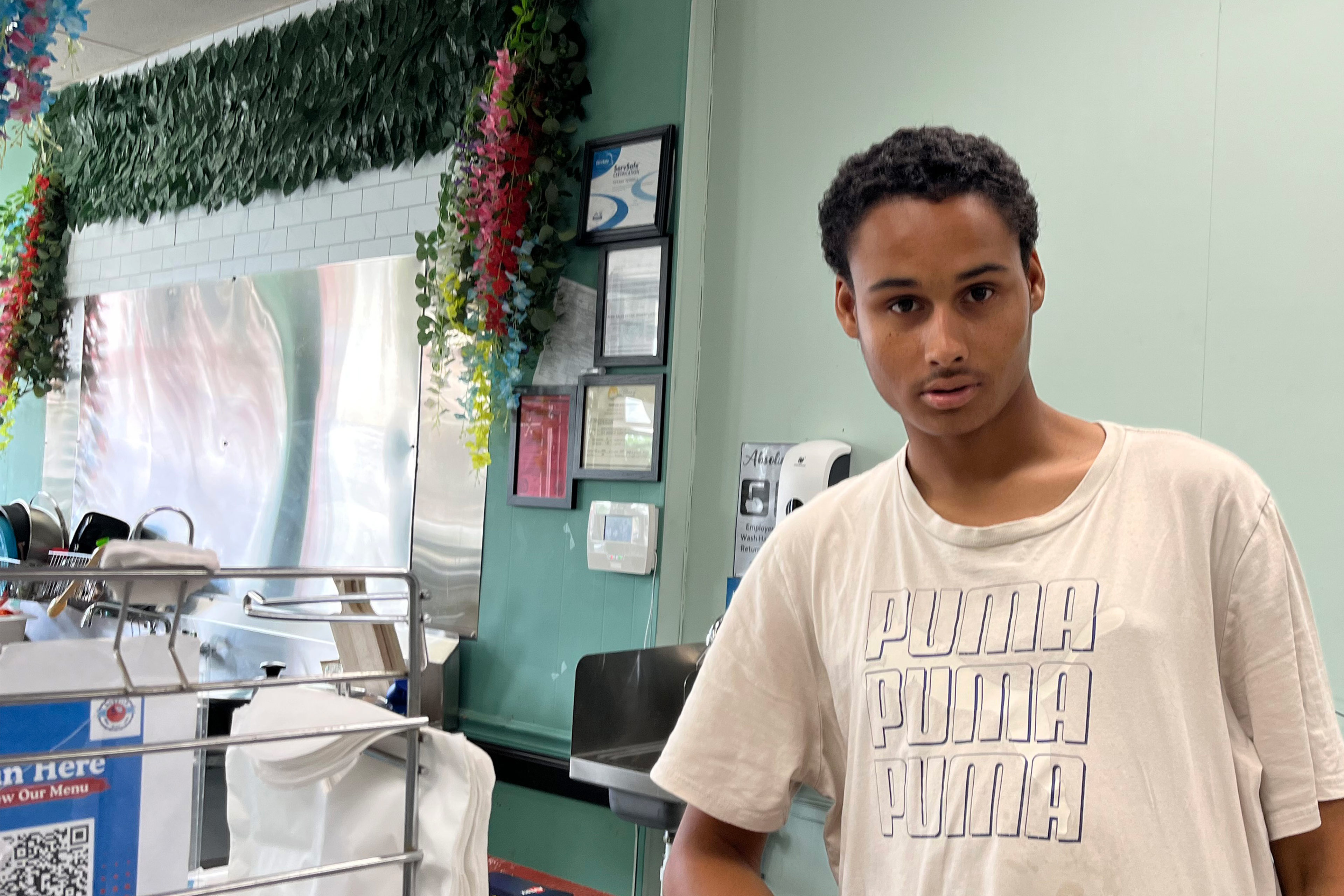 A photo of a young Black man posing for a portrait indoors.