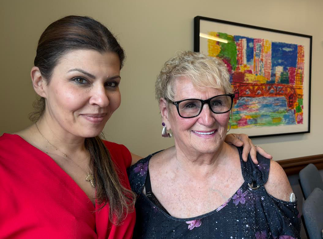 A photo of an older woman posing with a younger woman.