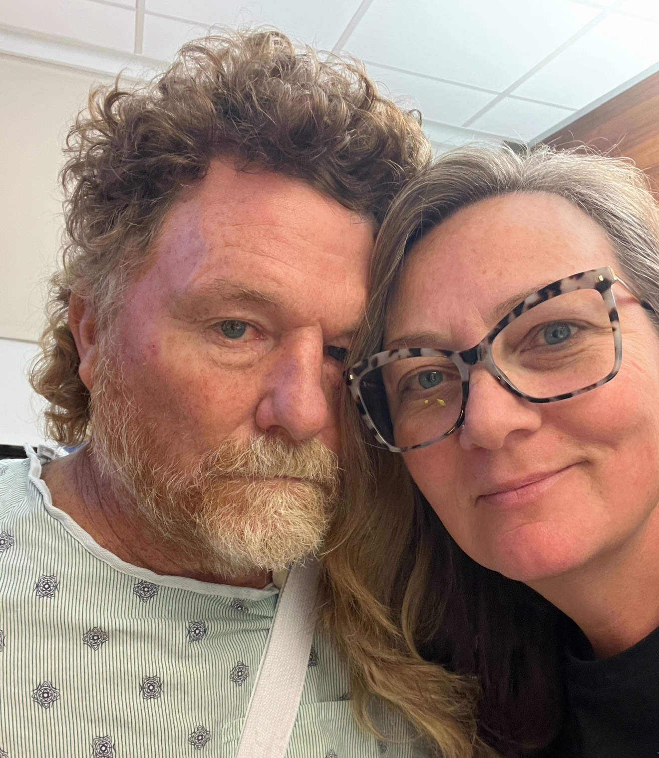 A photo of a husband and wife taking a selfie together indoors.