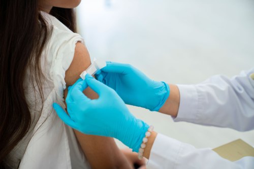 A photo of a bandage applied to a young girl's arm after vaccination.