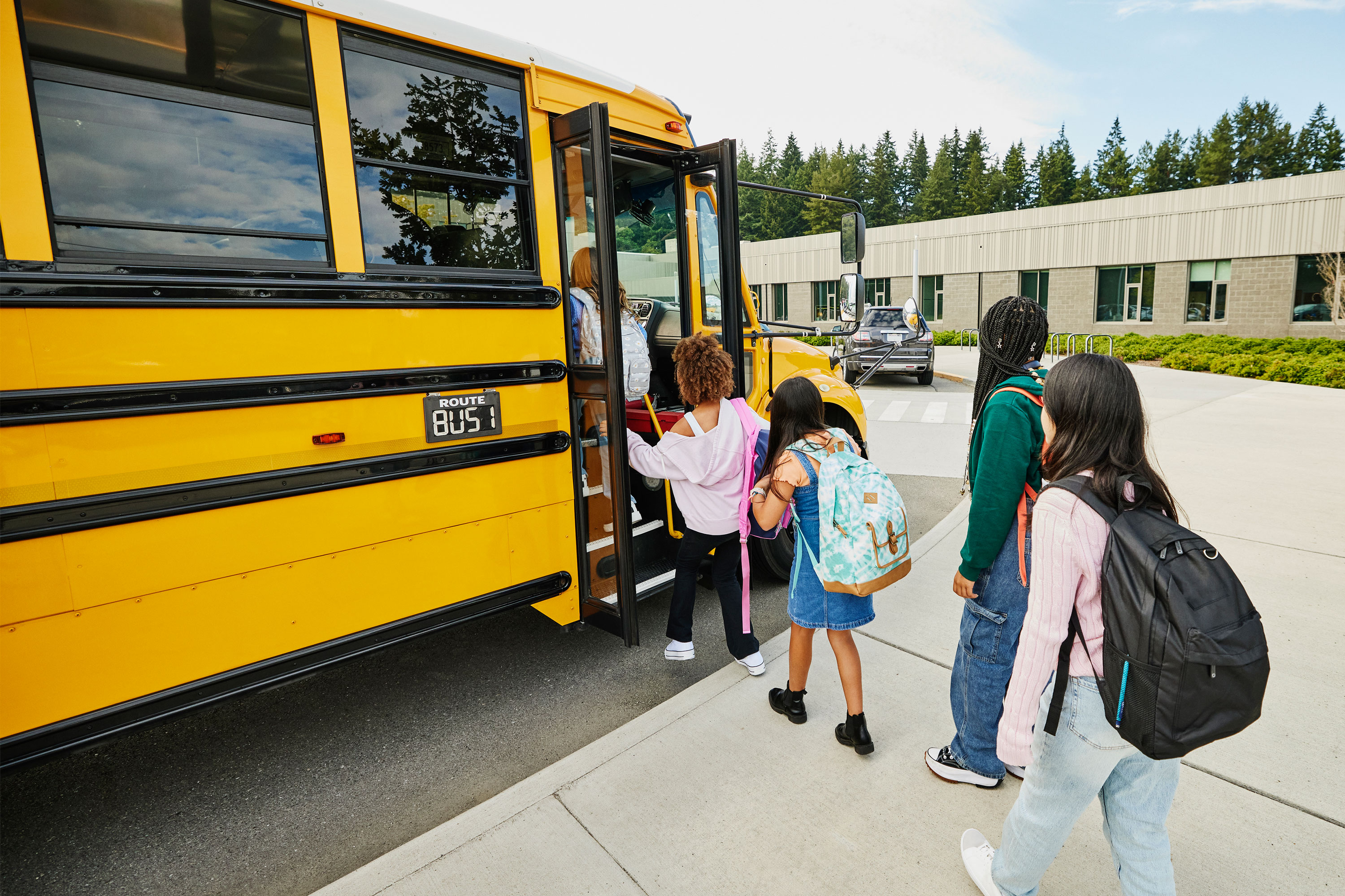 A photo of middle school students getting on a school bus.