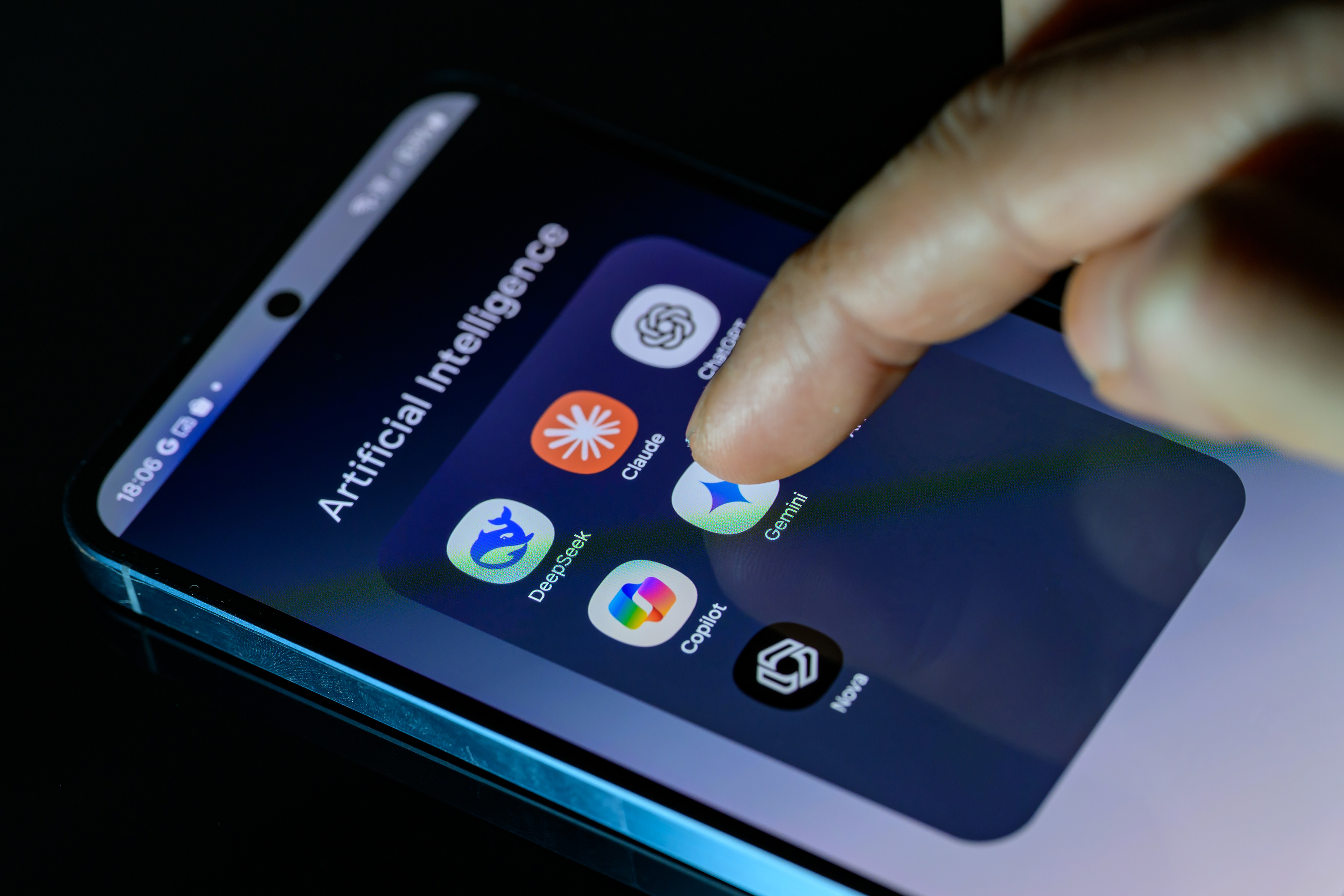 A photo of someone's smartphone with a folder full of AI apps: DeepSeek, Claude, ChatGPT, Copilot, Gemini, AI Photo, and Nova.