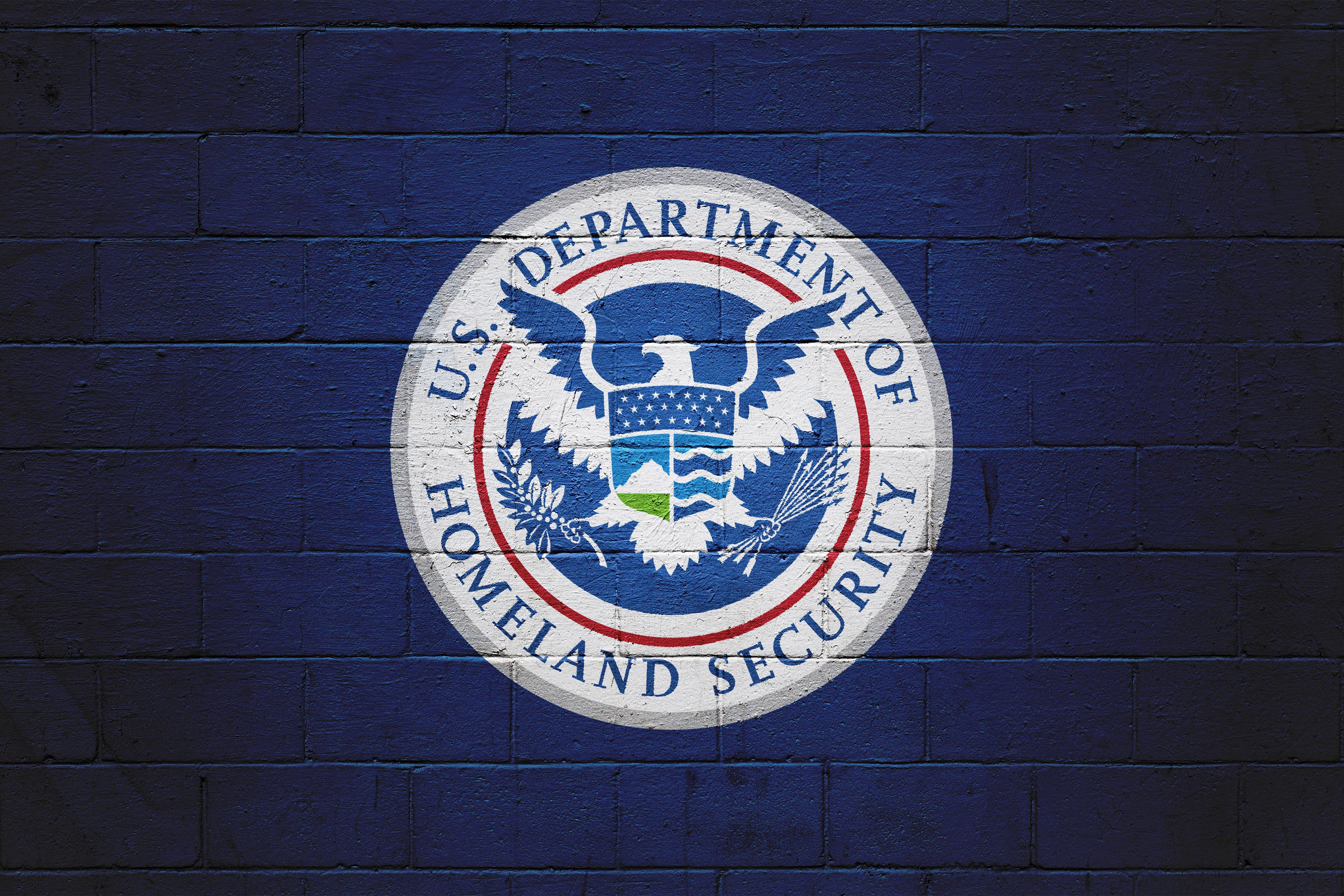 The emblem of the U.S. Department of Homeland Security is painted on a wall.