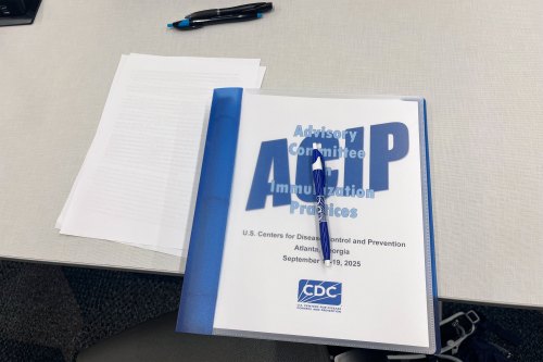 A binder rests on a table. The cover reads "Advisory Committee on Immunization Practices" and has the CDC logo on it.