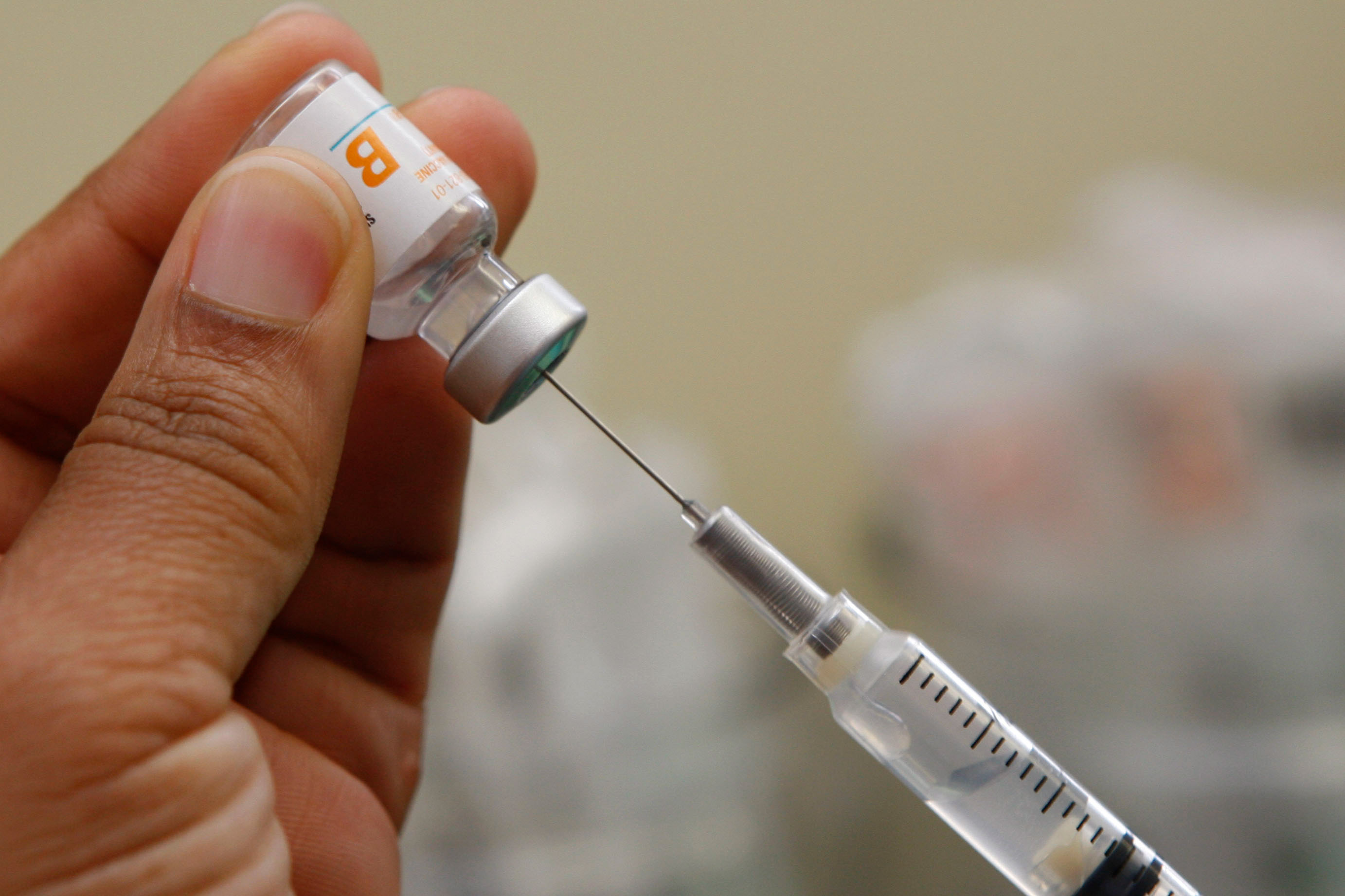 A photo of a person filling a syringe with a dose of the Hepatitis B vaccine.
