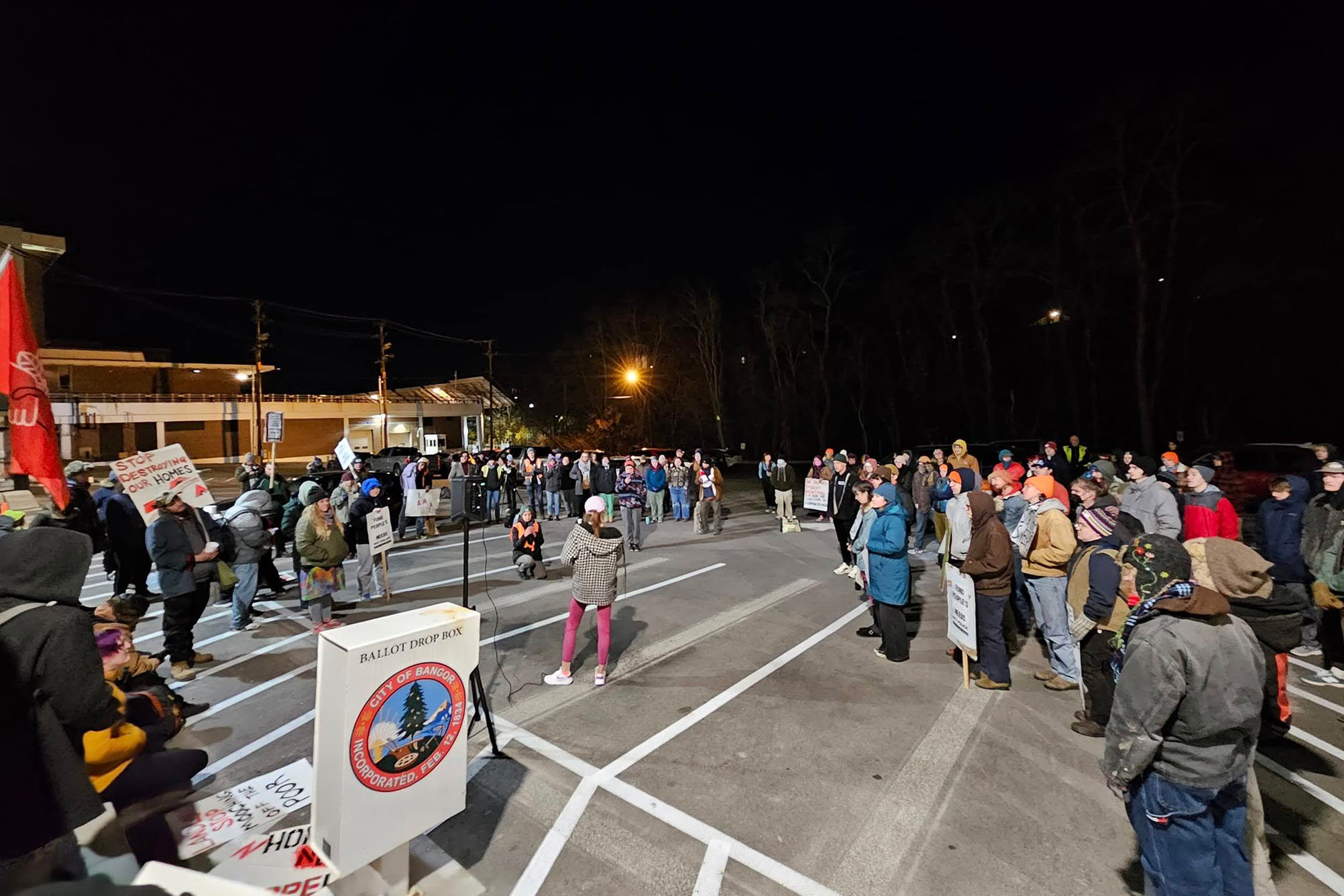A photo at night of demonstrators outside a city hall in Maine.