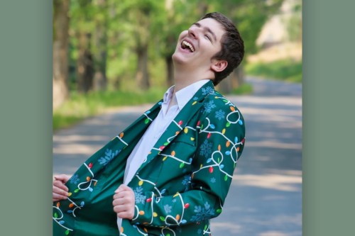 A photo of a teenage boy laughing outside.