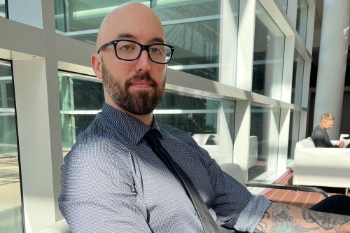 A photo of a man sitting indoors.