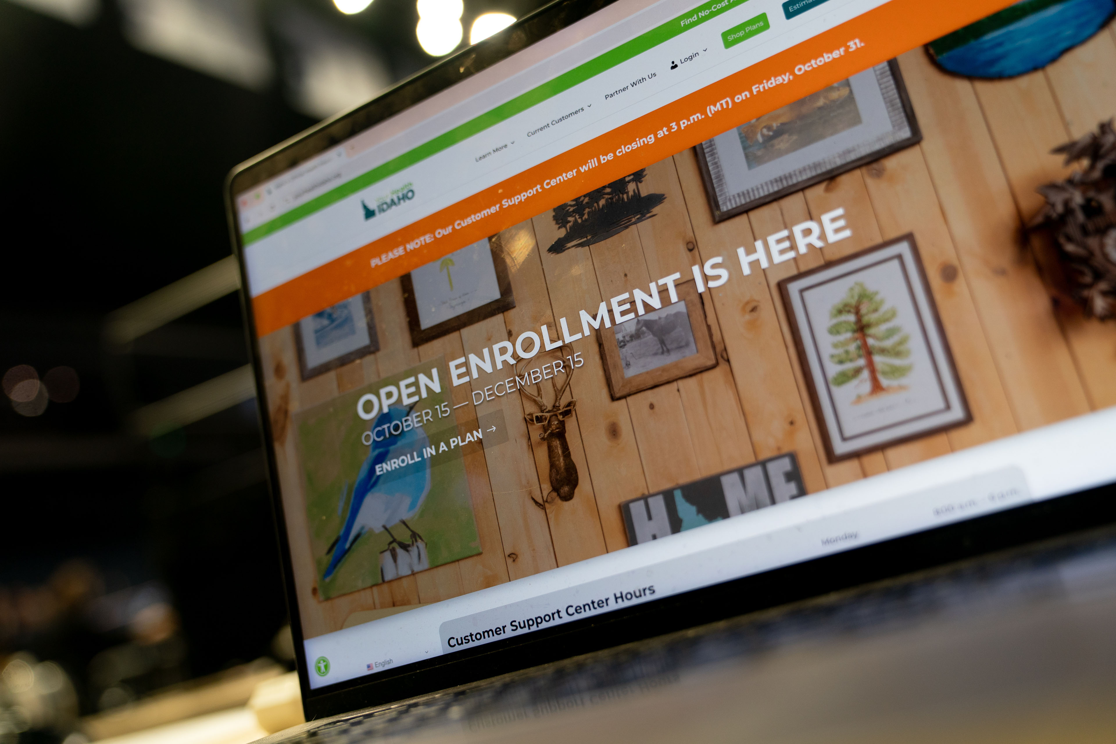 A laptop screen shows Idaho's Affordable Care Act marketplace website, with "Open Enrollment Ends December 15" in all-cap tyoe.