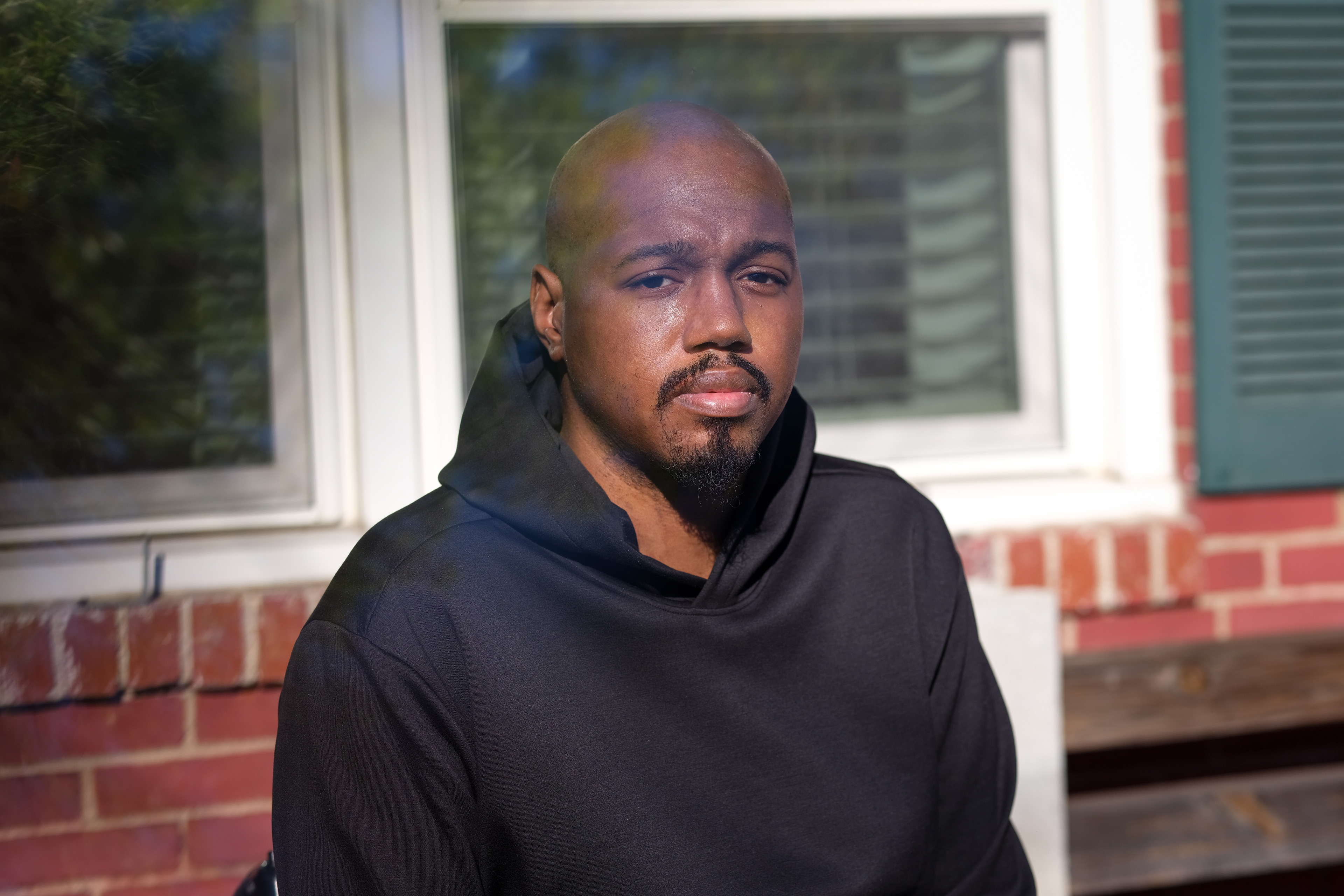 A photo of Leon Harris sitting outside his home.