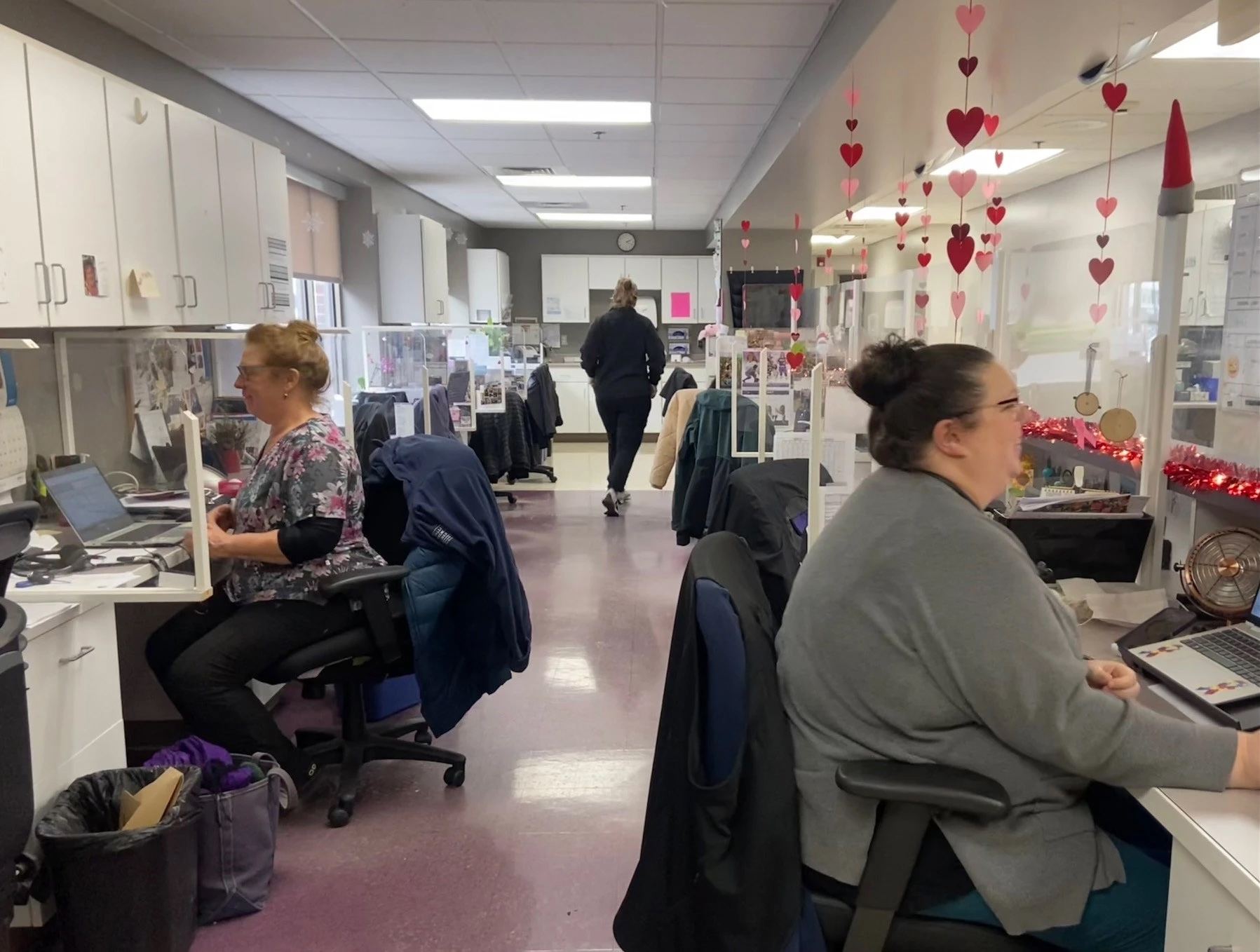 An administrative office with people seated at desks.