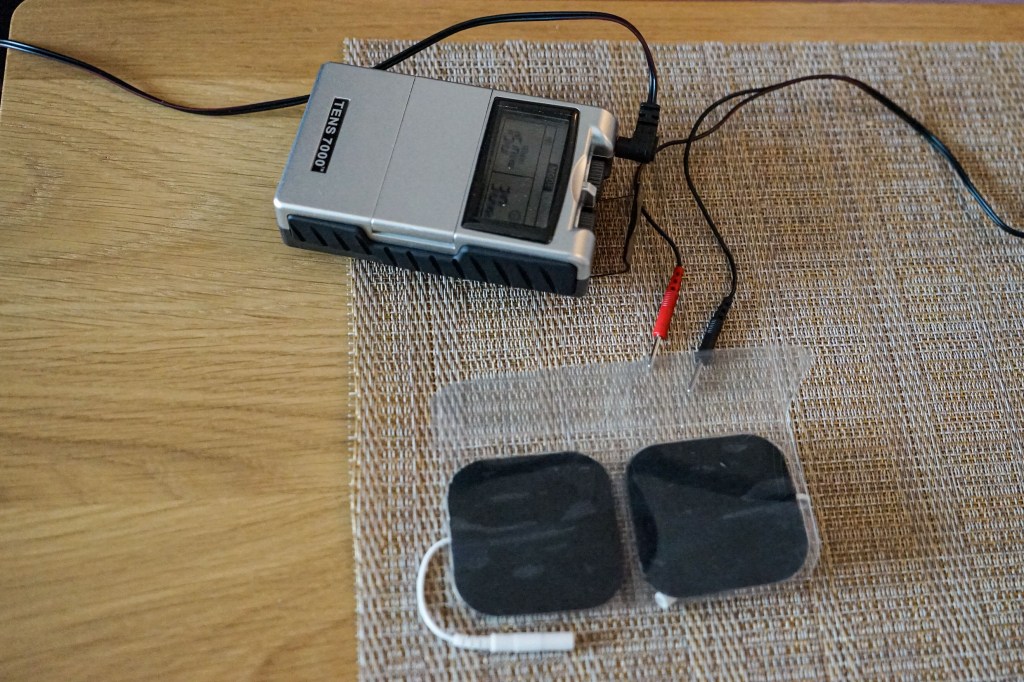 A small medical device rests on a wooden table.