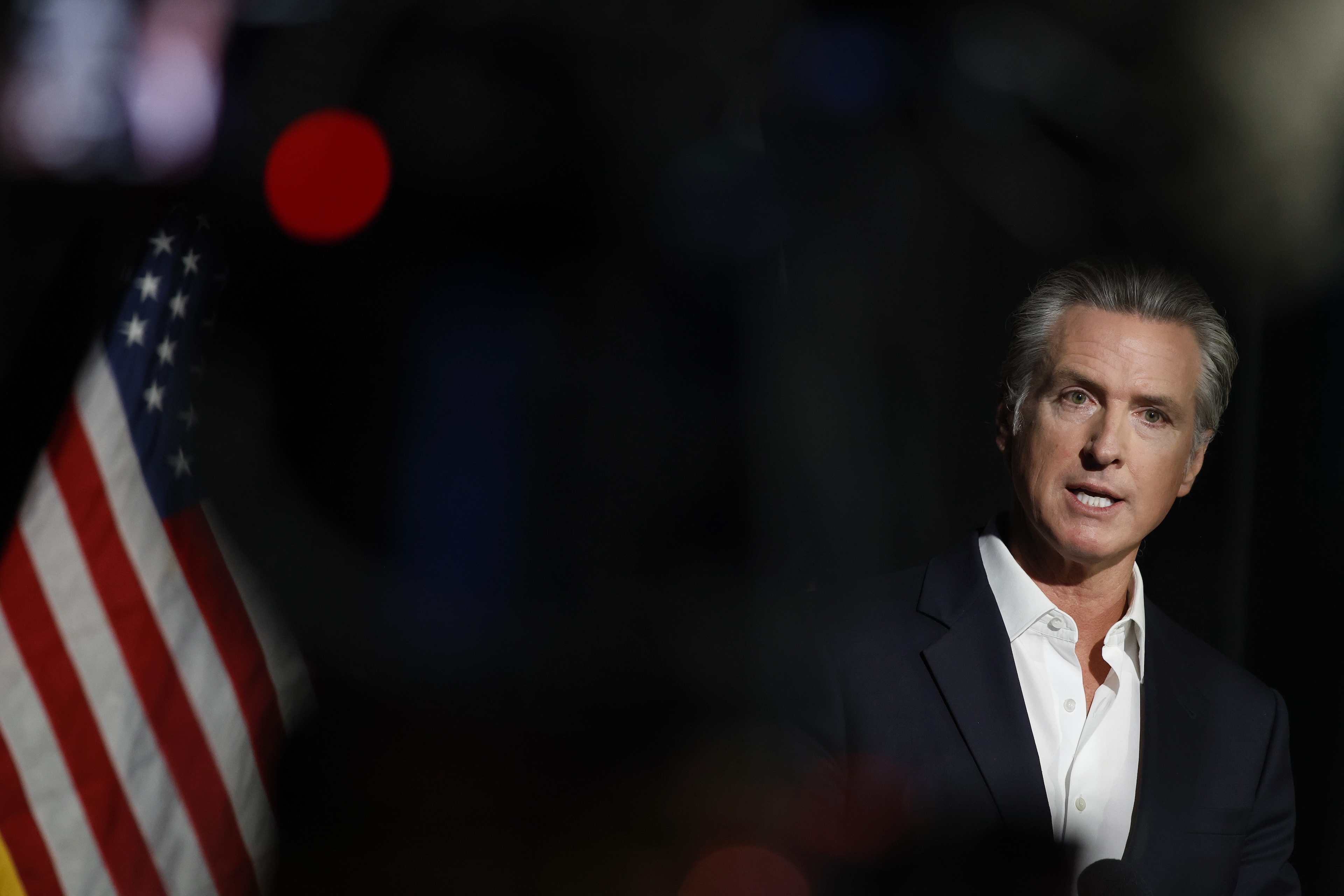 California governor Gavin Newsom stands before an American flag