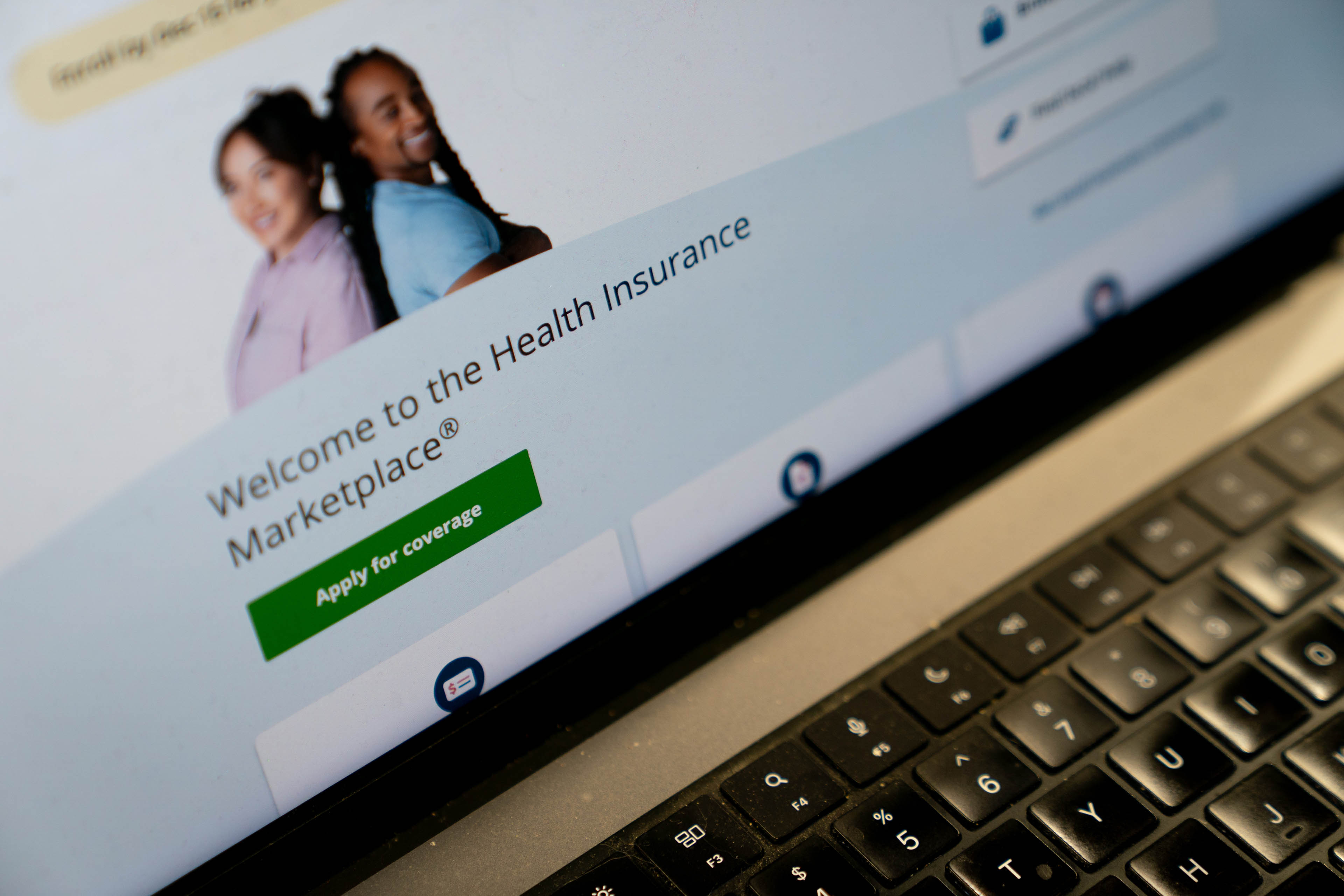The healthcare.gov website is visible on a laptop screen.
