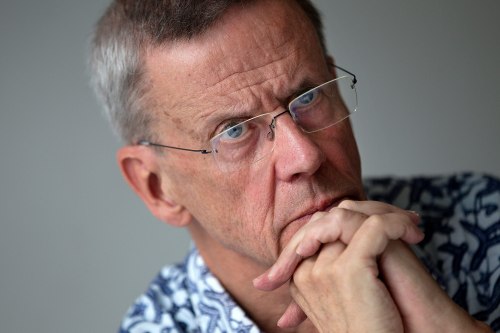 Peter Aaby sits at a table with his hands clasped. He rests his hands against his chin.