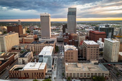An aerial view of downtown Omaha at dawn. Several cars are driving on the roads.