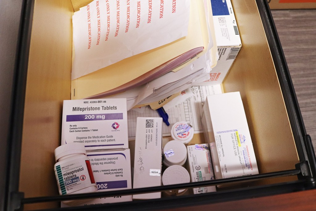A drawer containing mifepristone and misoprostol, documents, and other medications.