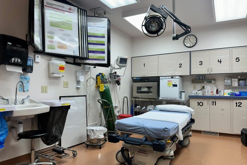 A photo of a small emergency room. Only one bed is visible.