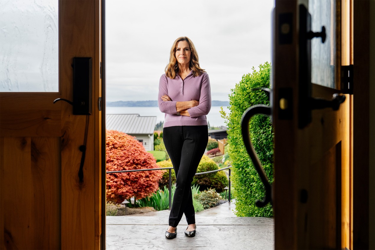 Jan Anderson stands on her porch, framed by doors on both sides.