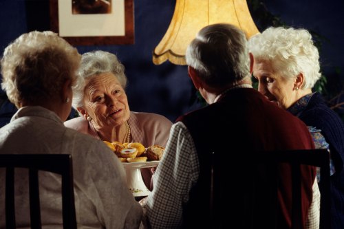 A photo of four older adults sitting around a dinner table.