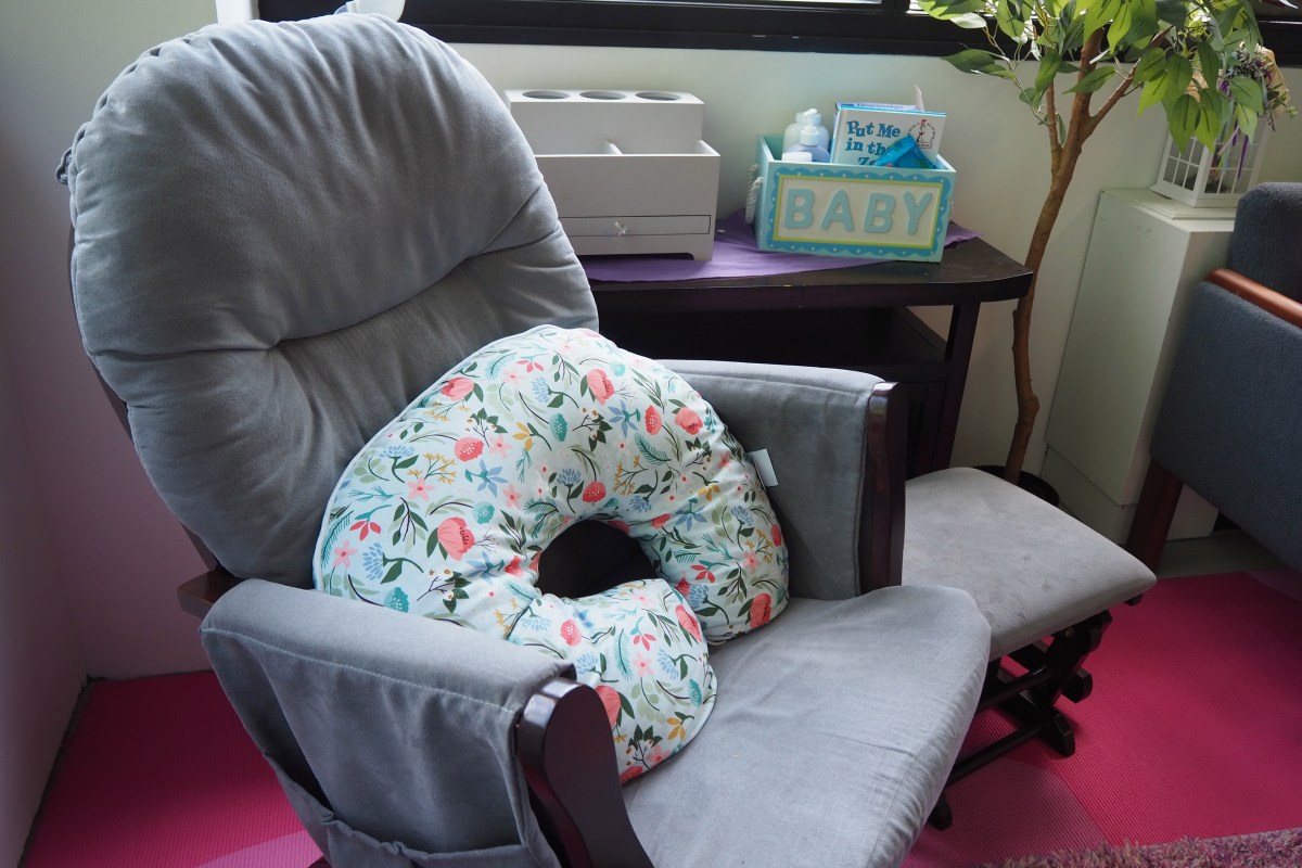 A picture of a rocking chair with a breastfeeding pillow