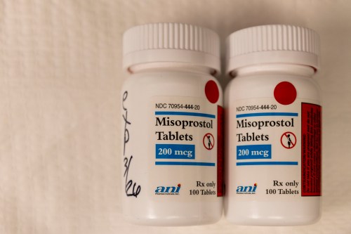 Two plastic bottles of misoprostol lay side by side.