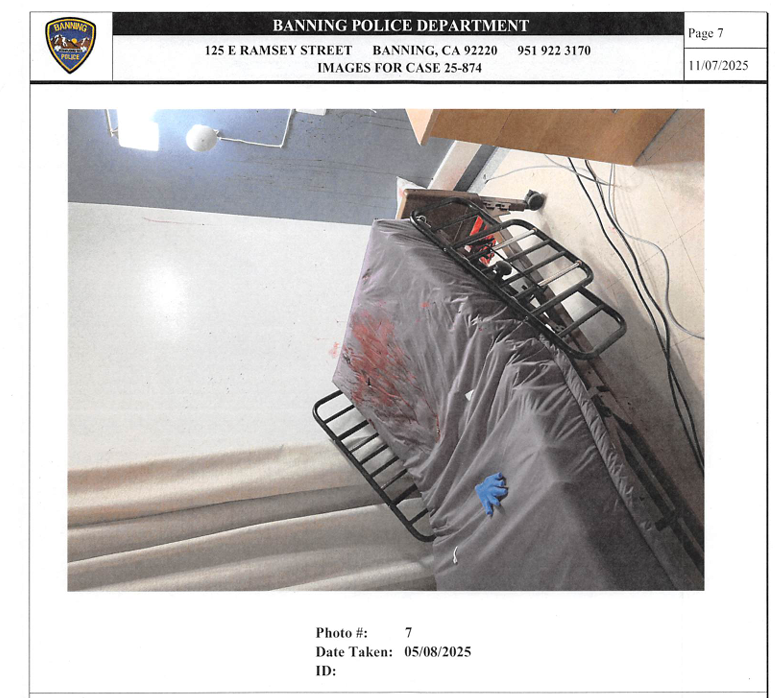 A gurney with blood and a blue medical glove on the mattress