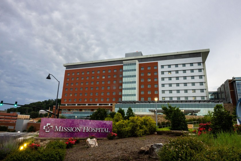 An image of a large hospital building with a sign in front that reads "Mission Hospital"