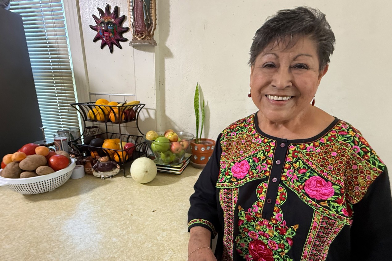 A woman with short gray hair smiles towards the camera.