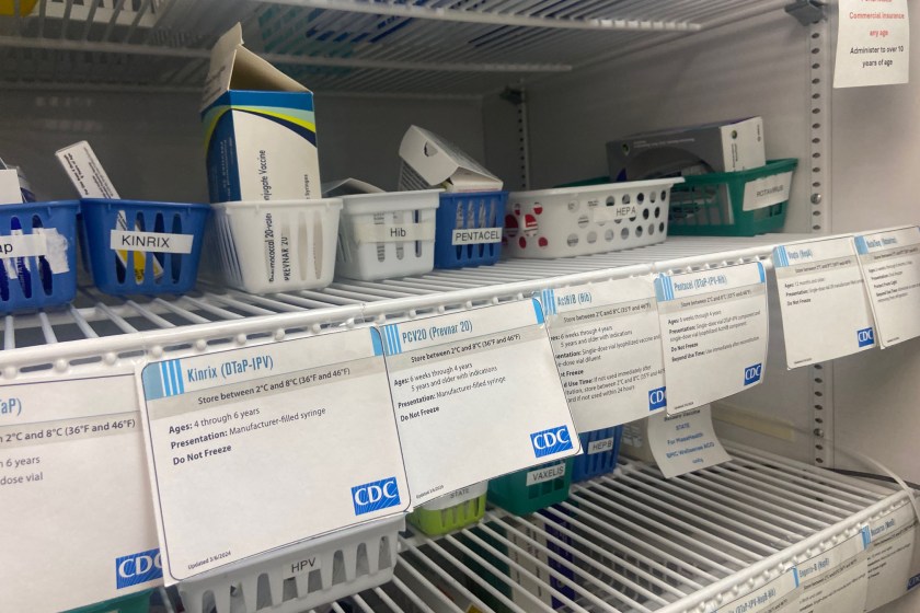Medical products in white baskets rest on a shelf with CDC labels in front of them.