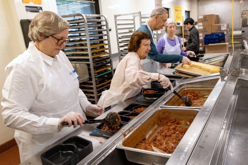 Volunteers serve meals at a soup kitchen