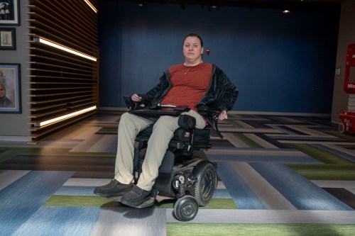 A woman sits for a photo in her wheelchair.