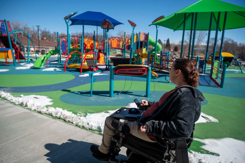 Erica Carter in her wheelchair seated next to a playground.