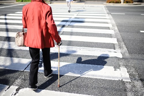 A senior woman crossing the street.