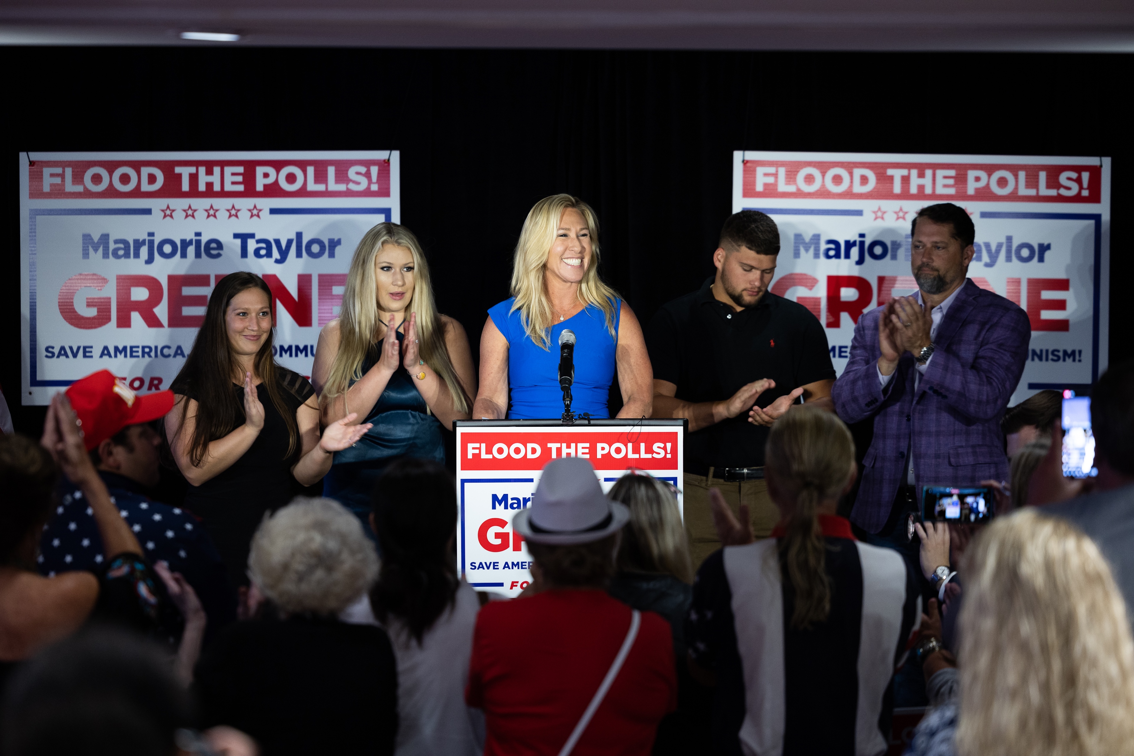Marjorie Taylor Greene stands behind a podium