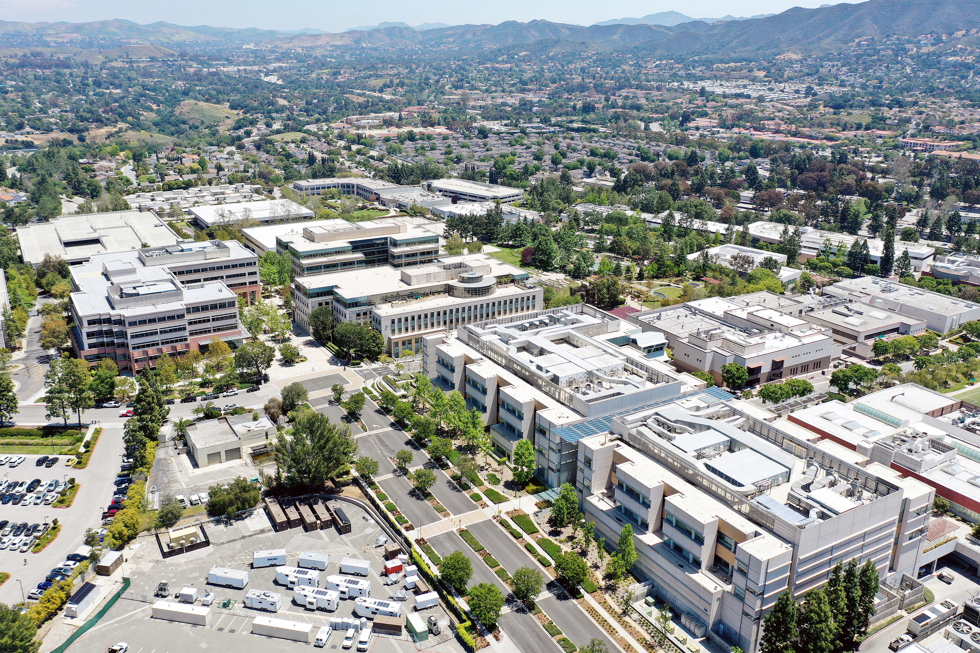 An aerial photo shows a large company headquarters with various buildings.