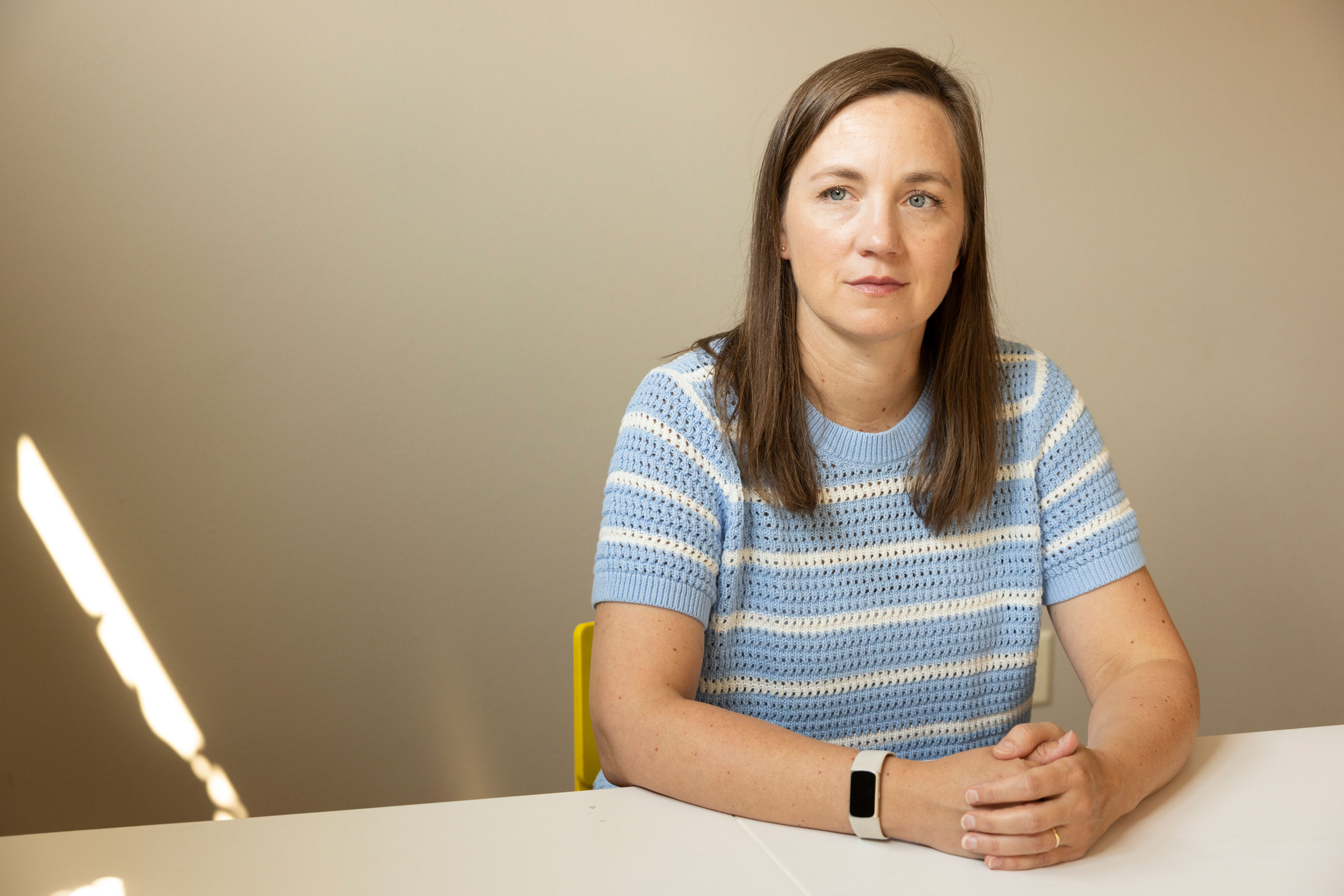 Stephanie Halver sits at a table in her home.