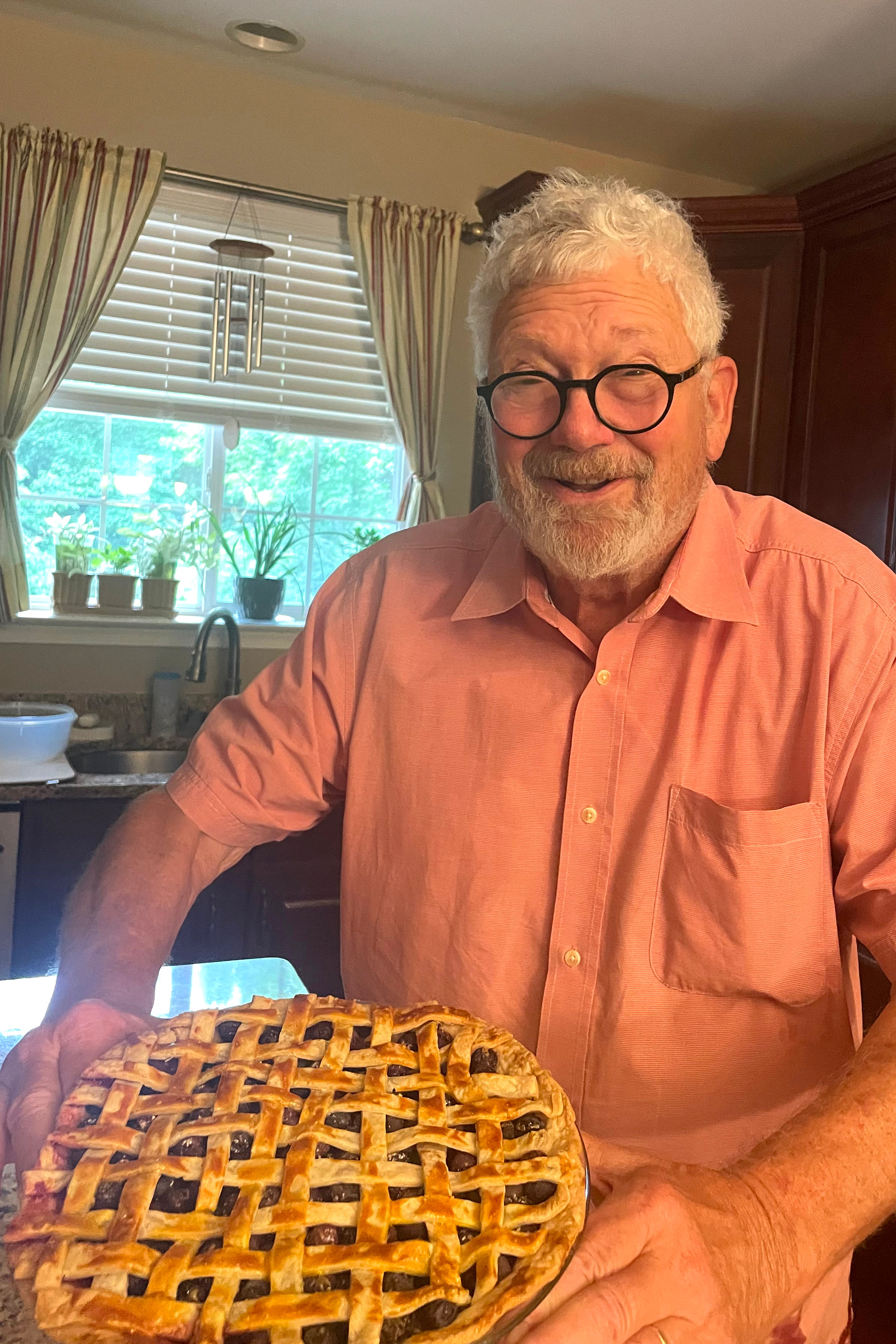 A photo of Mike Salmon holding up a blueberry-cinnamon pie.