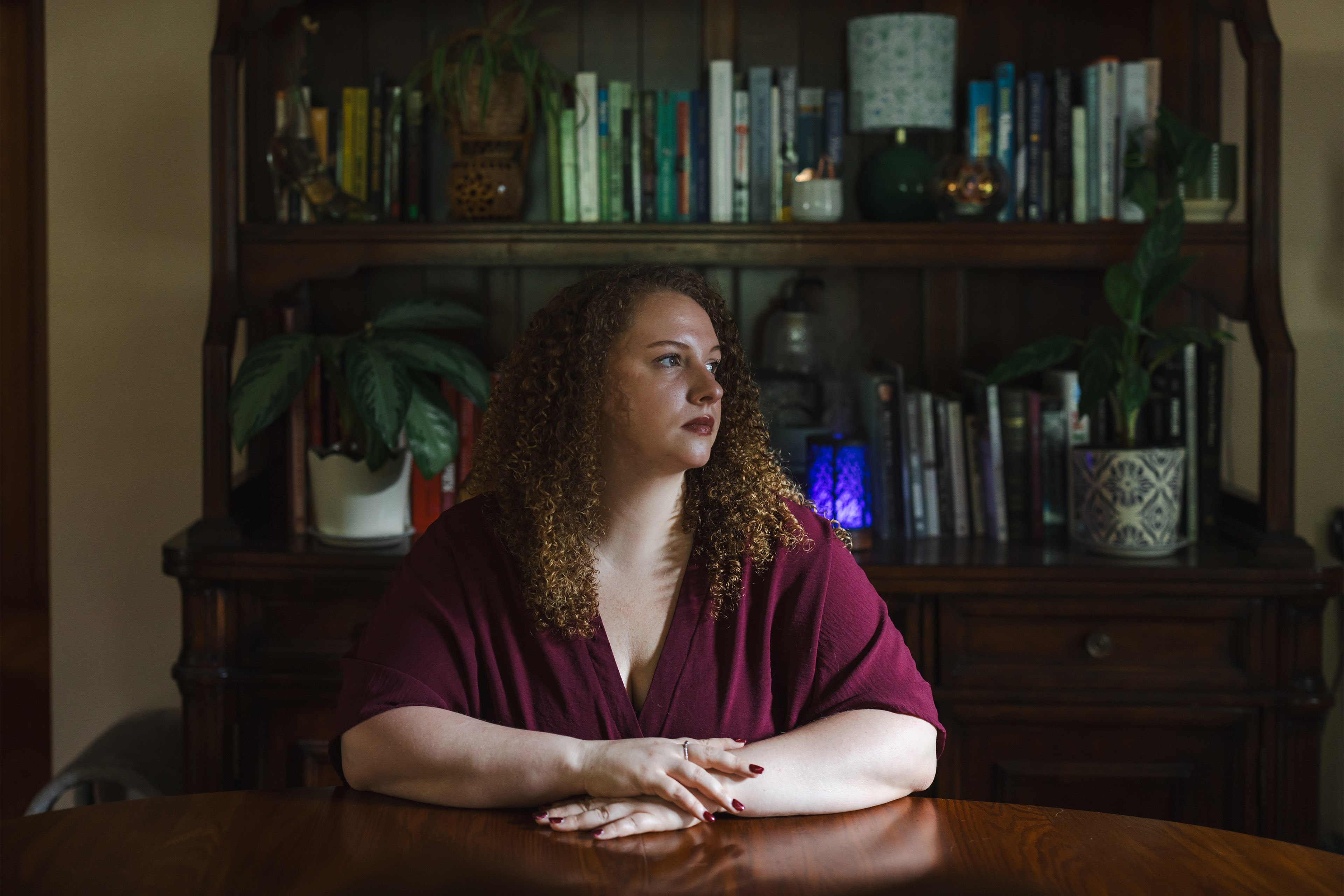 Daniels sits at a table with her arms folded on the table.