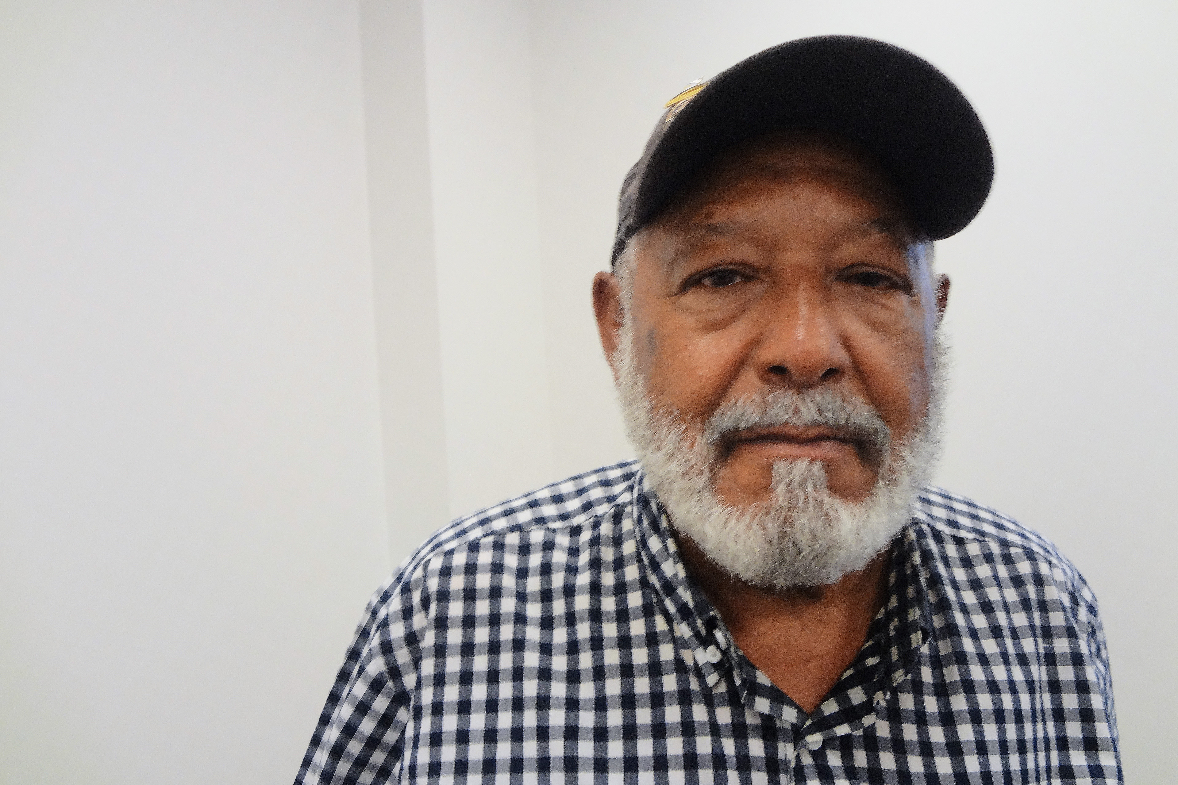 A photo of a Black man seated and facing the camera.
