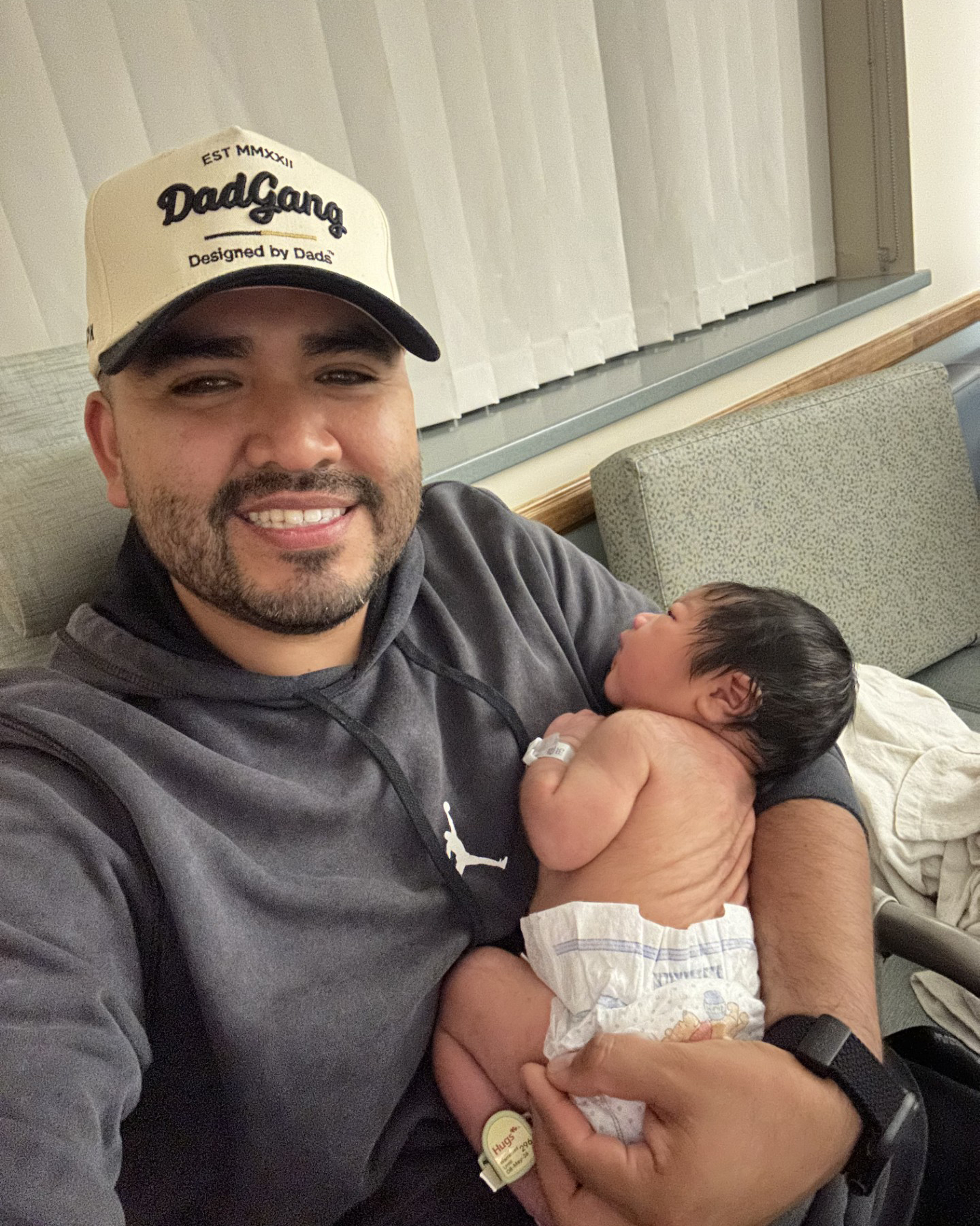 Karlo Campana takes a selfie as he holds his newborn son.