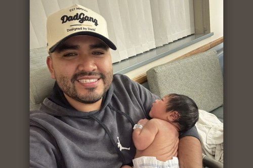 Karlo Campana takes a selfie as he holds his newborn son.