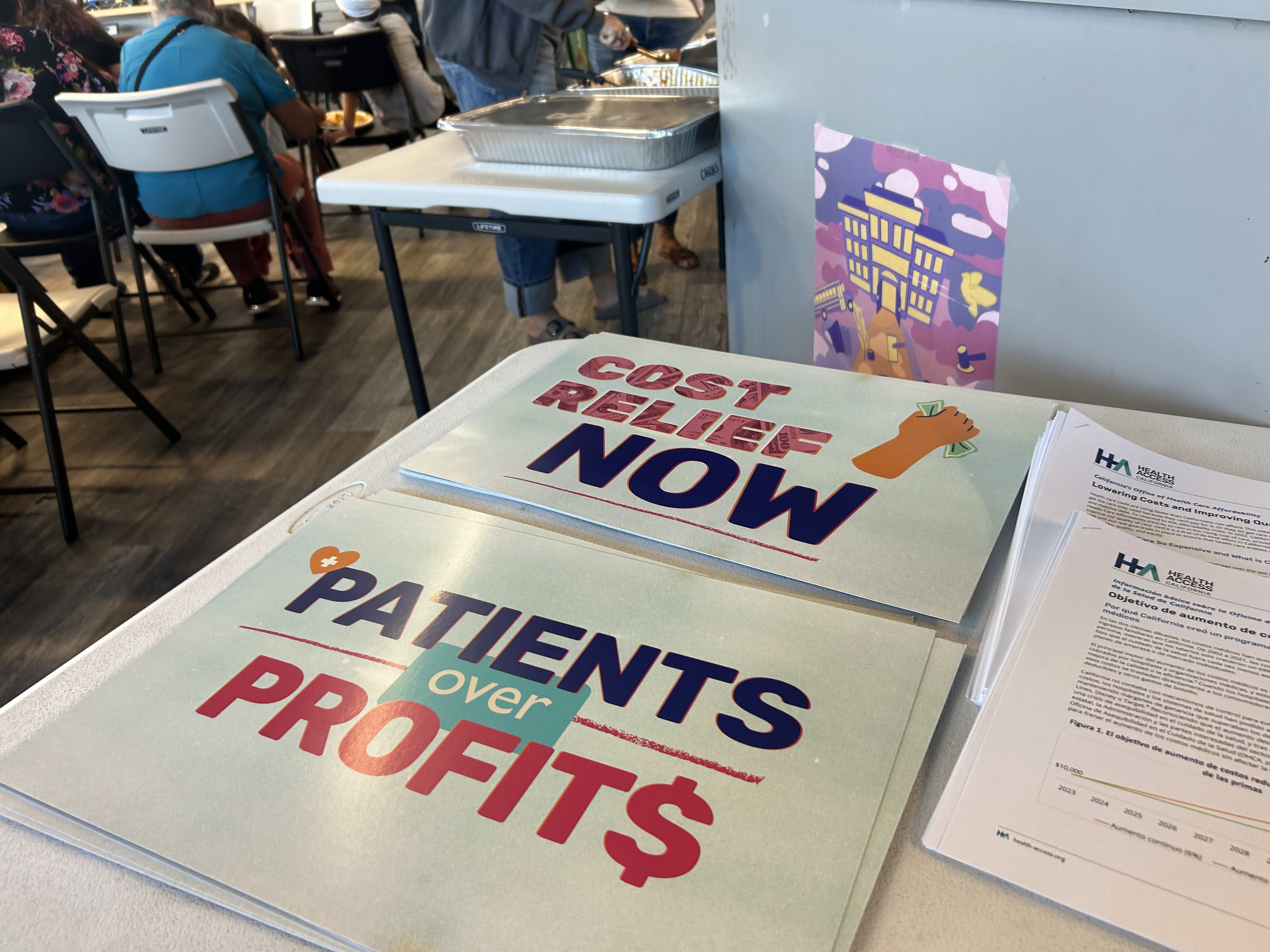 A photo of a table with flyers that read "Cost relief now," and  "Patients over profits."