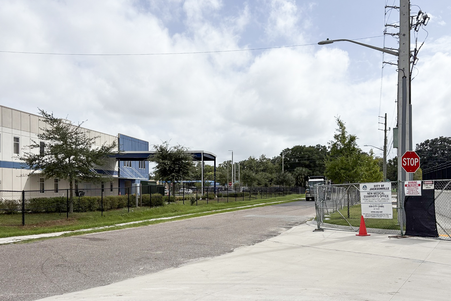 A photo of a street shows the exterior of a public charter school on the left side. On the right is a fence with a sign that reads, "City of Jacksonville, New Medical Examiner's Office."